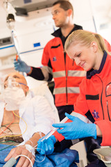 Wall Mural - Paramedics injecting sick patient in ambulance aid