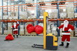 two santa clauses workers at work in large storehouse