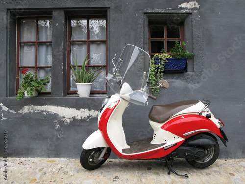 Naklejka na szybę Trendy moped against old house. Fribourg, Switzerland