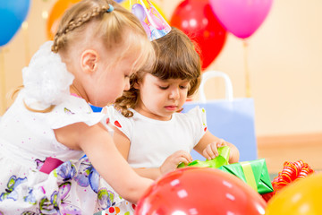 pretty children with colorful balloons and gifts on birthday par