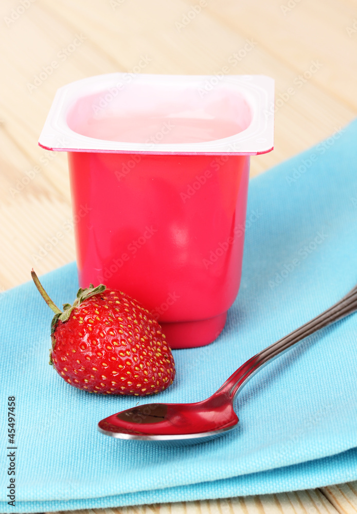 Yogurt with strawberry on wooden table
