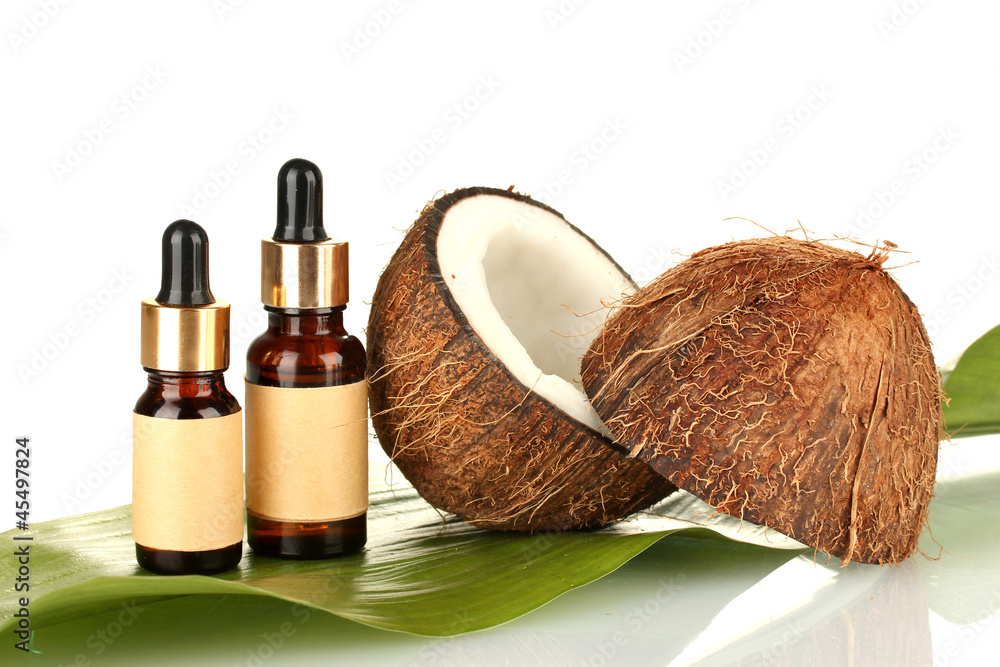 coconut oil in bottles with coconuts on white background