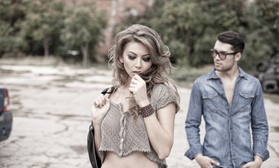 Sexy and fashionable couple wearing jeans, grungy location