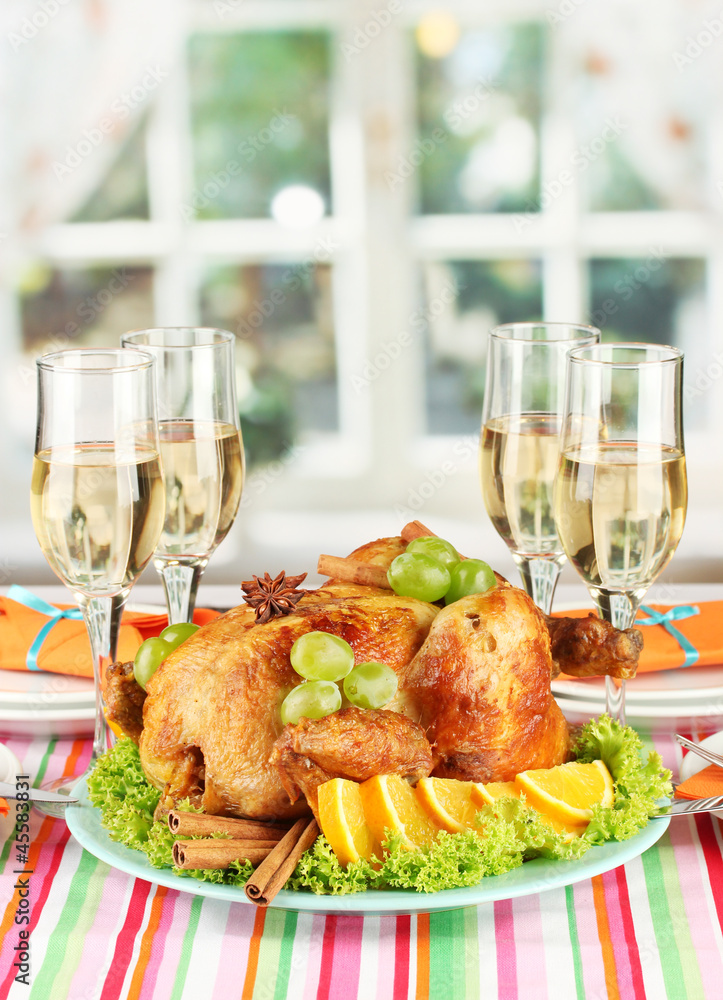 banquet table with roast chicken and glasses of wine.