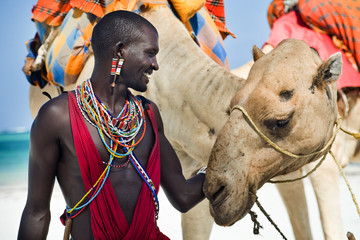maasai sitting by the ocean on the beach