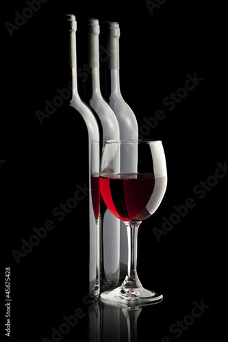 Tapeta ścienna Eleganckie czerwone wino i butelki wina w czarnym tle