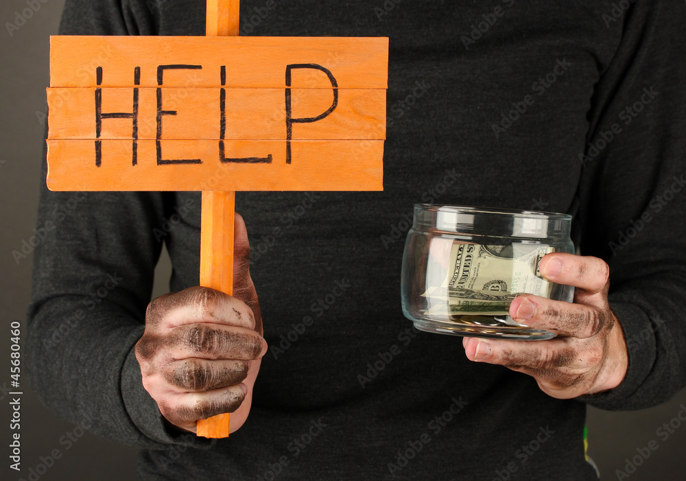 homeless man asks for help, on black background close-up