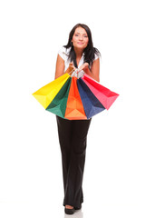 Portrait of young woman carrying shopping bags against white bac