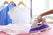 © Africa Studio - Woman hand ironing a shirt, on cloth background