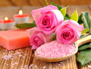 Wall Mural - Sea salt, rose, soap and a burning candle on a brown table