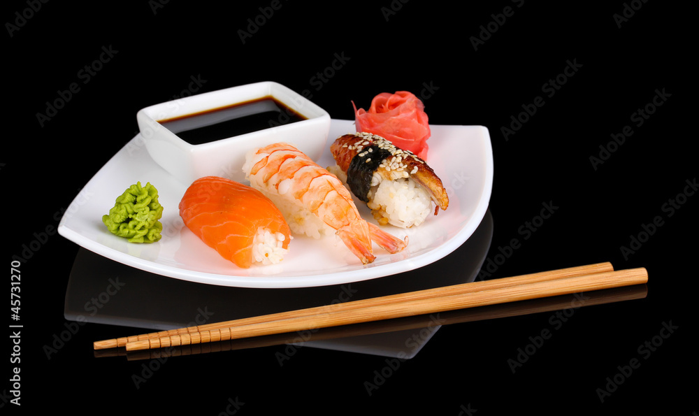 delicious sushi served on plate isolated on black