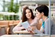 © Karramba Production - Two girls communicate sitting at the table at the reading hall