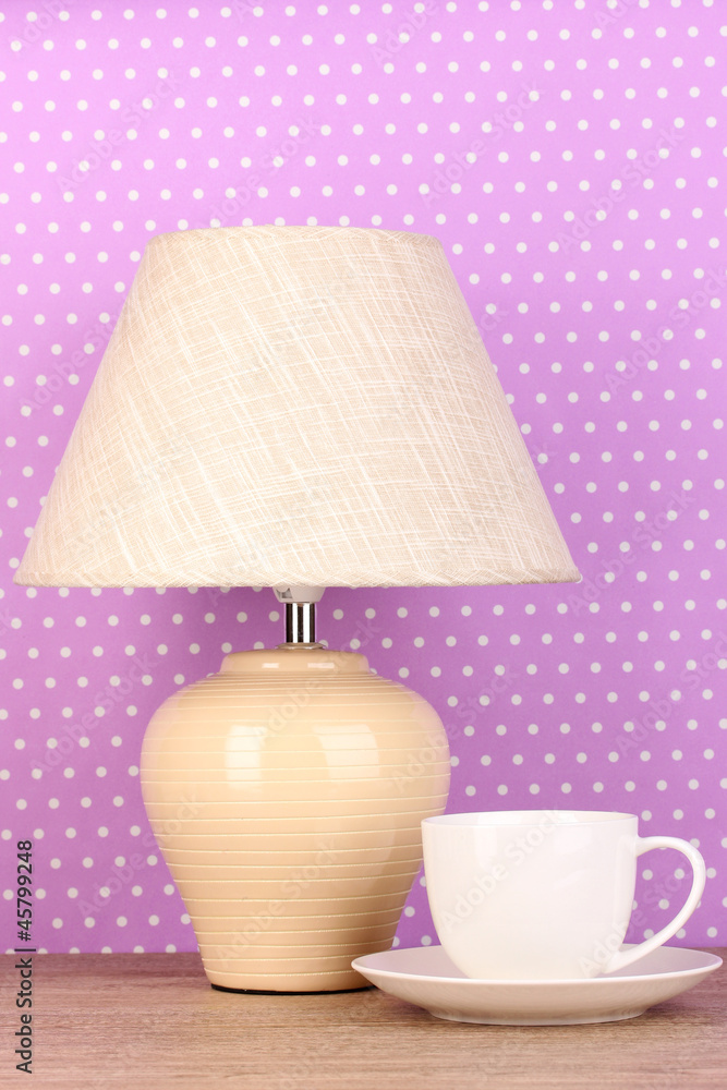 table lamp and cup on purple polka dot background