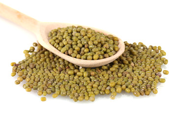 Mung beans over wooden spoon isolated on white