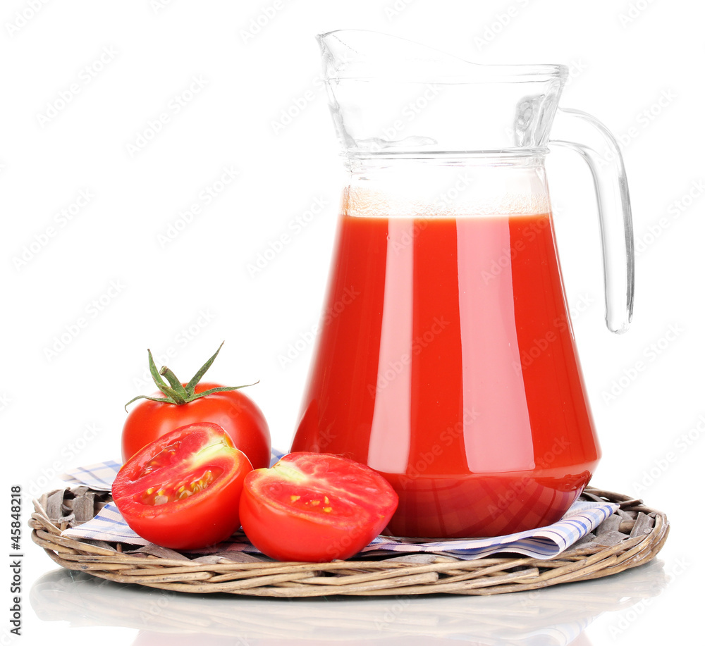 Tomato juice in pitcher on wicker mat isolated on white