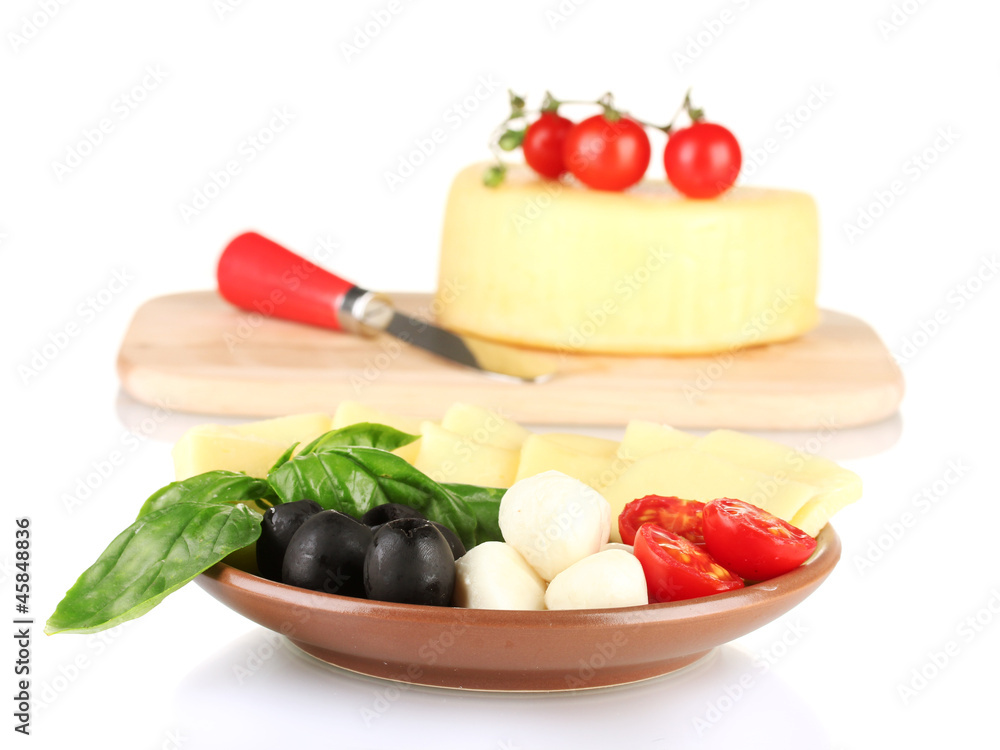 sliced mozzarella cheese with vegetables in the plate isolated