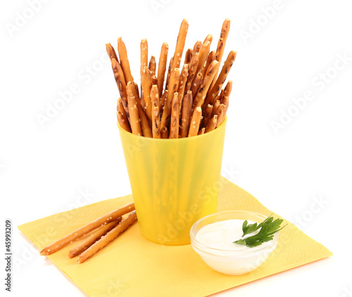 Tasty crispy sticks in yellow plastic cup isolated on white © Africa Studio