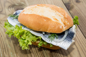 Wall Mural - Fresh Herring on a roll (wooden background)