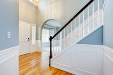 Blue Empty Entrace With White Molding And Staircase.
