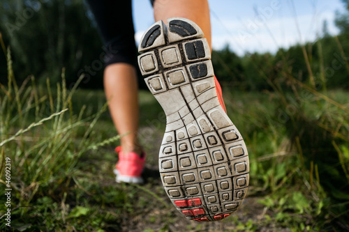 Board z aluminiowym obramowaniem Kobieta i buty do biegania w lesie, ćwiczenia w przyrodzie
