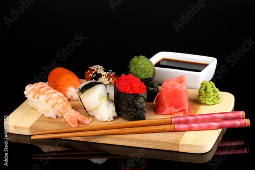 Tapeta ścienna Pyszne sushi serwowane na desce izolowanych na czarno