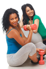 Portrait of 2 beautiful girl posing in studio with dumbbells