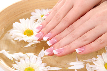 Wall Mural - Woman hands with french manicure and flowers in bamboo bowl