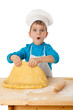 Little boy kneading the dough
