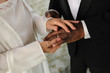 elderly mixed couple exchanging wedding rings
