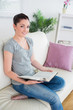 © WavebreakMediaMicro - Woman sitting on the couch while holding a book