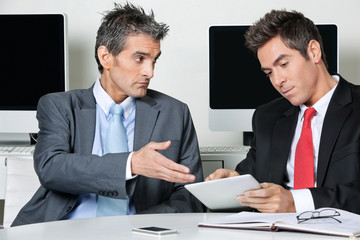 Businessmen Using Digital Tablet At Desk