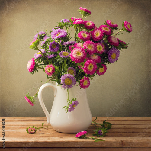 Fototapeta na wymiar Beautiful aster flower bouquet on wooden table