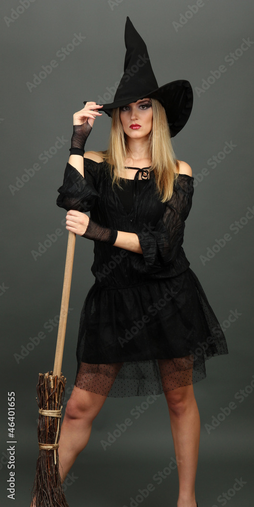 Halloween witch with  broom on gray background