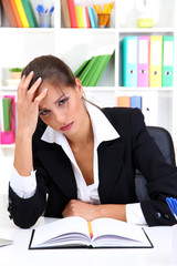 Canvas Print - Tired business woman with documents in her workplace