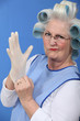 © auremar - Granny with her hair in rollers putting on a latex glove
