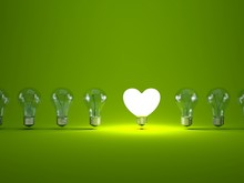 Heart Shaped Light Bulb On Green Background