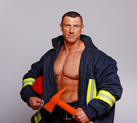 Portrait of handsome man posing on black background in fireman c