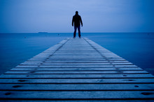 Man Standing On A Wooden Pier