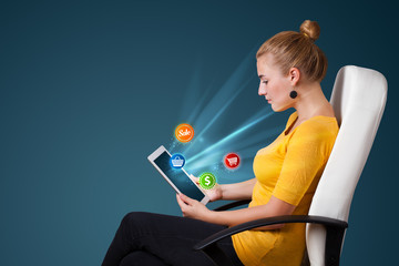 Young woman looking at modern tablet with abstract lights and va