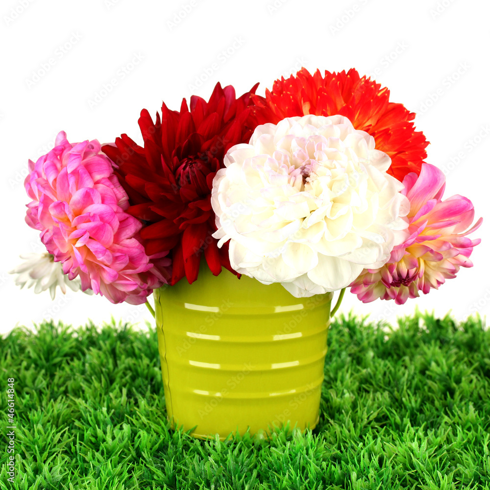 Flowers in vase on grass isolated on white