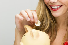 Young Woman In Santa Hat Holding Piggy Bank