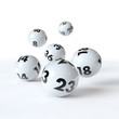 6 Lottokugeln rollen auf weißem Hintergrund