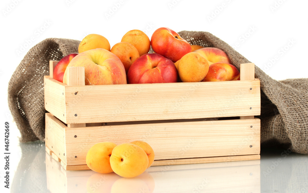 Ripe fruit in wooden box on white background close-up