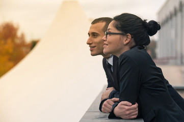 Couple of businessman and woman looking forward outdoors.