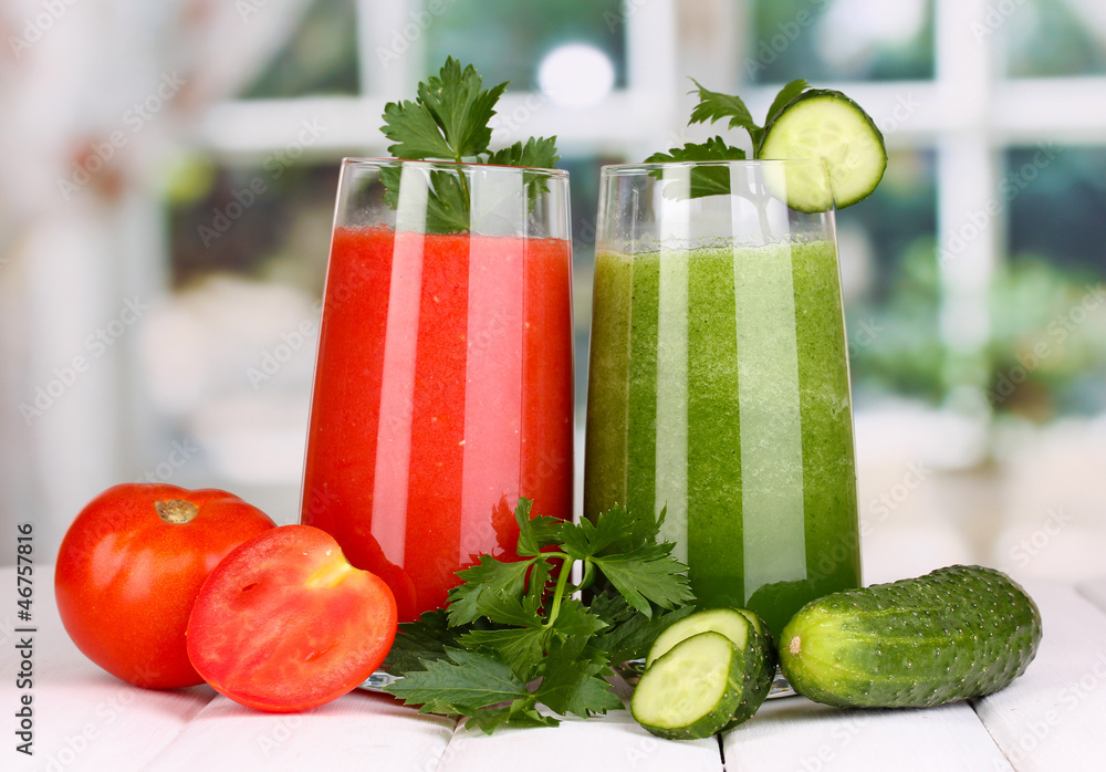 Fresh vegetable juices on wooden table, on window background