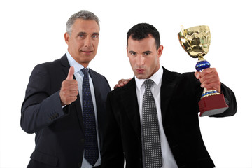 businessmen with a trophy