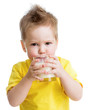 Funny angry kid drinking dairy product from glass isolated on wh