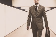 Man In Classic Suit With Briefcase Walking Through Corridor