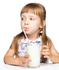 Cute little girl drinks milk using drinking straw