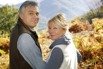 Wall Mural - Portrait of smiling senior couple in countryside